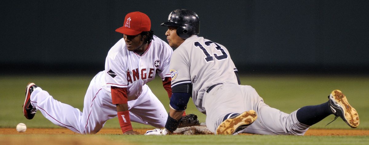 Erick Aybar of the Angels can’t handle the throw as the Yankees’ Alex Rodriguez (13) slides safely into second for a sixth-inning double.  (Associated Press / The Spokesman-Review)
