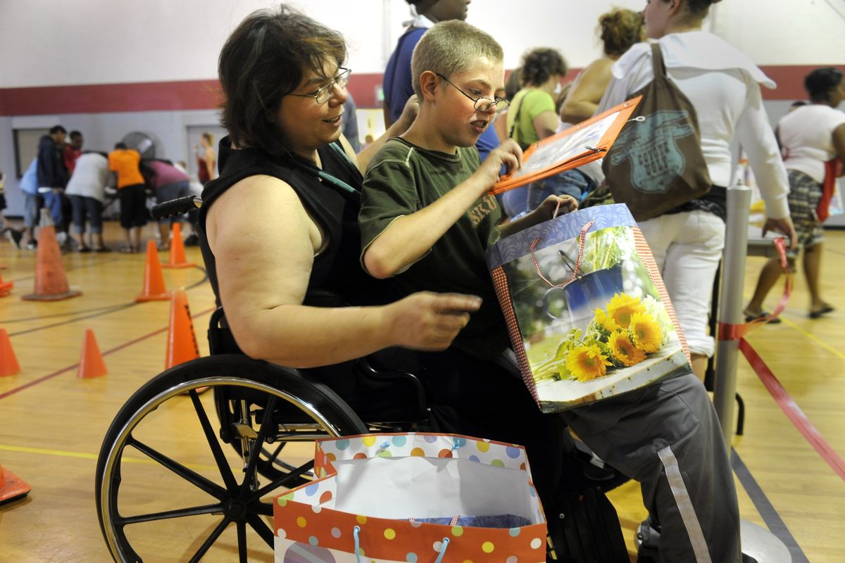 Joseph Sloan, 12, shows his mother, Karla Tull, the color of his new pencil case from a bag of school supplies he received at the Salvation Army in Spokane on Monday. The Salvation Army ran out of supplies in about an hour. (Jesse Tinsley / The Spokesman-Review)