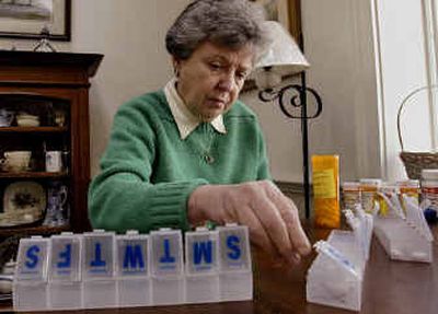 
Sitting at her table in Plymouth, Mass., Alice Hickman sorts her daily medications into containers with compartments for each day of the week. 
 (Associated Press photos / The Spokesman-Review)