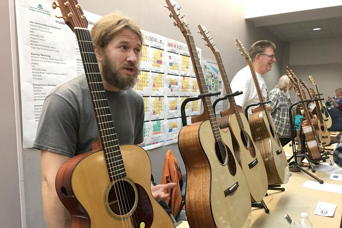 Luthiers Joel Shoemaker, left, and Rob McAllister, second from left, talk with potential customers about their instruments at the Fall Folk Festival Sunday, Nov. 12, 2017 at Spokane Community College. In addition to dozens of acts given 30-45 minutes each to perform, vendors of many kinds sell their wares at the festival. (Jesse Tinsley / The Spokesman-Review)