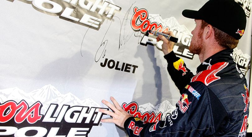Brian Vickers, driver of the No. 83 Red Bull Toyota, signs the wall in Victory Lane after qualifying for his fifth pole of the 2009 season. He will start in the front row next to his teammate Scott Speed, driver of the No. 82 Red Bull Toyota, on Saturday in the NASCAR Sprint Cup Series LifeLock.com 400 at Chicagoland Speedway. (Photo Credit: Jason Smith/Getty Images for NASCAR) (Jason Smith / The Spokesman-Review)