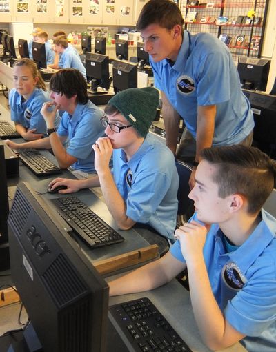 Central Valley High School students – from left, Riley Madrian, Daniel Powers, Kenneth Yergen, Billy Calligan (standing), and Isaiah Noble – concentrate during the first round of a CyberPatriots competition Saturday. It was the team’s first time in the competition which ran six hours.