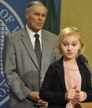 OLYMPIA -- Courtney Anderson, 23, of the Spokane Valley, explains at a press conference with Gov. Jay Inslee how Obamacare allowed her to stay on her parents' insurance, which covered her treatment for colon cancer last year. Without it, she might have been denied because of a pre-existing condition.  (Jim Camden/The Spokesman-Review)