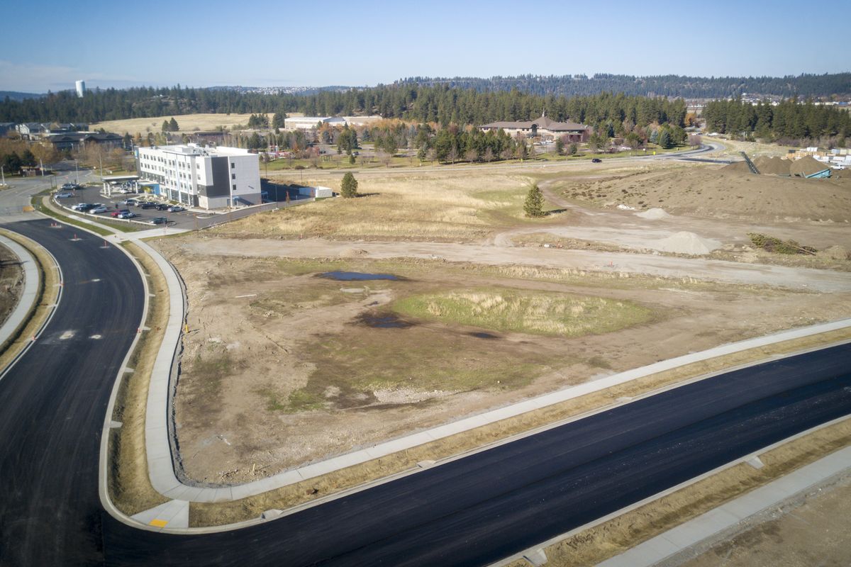 The proposed Spokane Valley Performing Arts Center is set to be built on the empty land in the foreground, next to the new Tru by Hilton hotel, which sits at East Mansfield, left, and Mirabeau Parkway. CenterPlace Regional Event Center, upper right, the Valley YMCA and Discovery Playground can be seen in the background, not far from Mirabeau Park and the Spokane River.  (Jesse Tinsley/The Spokesman-Review)