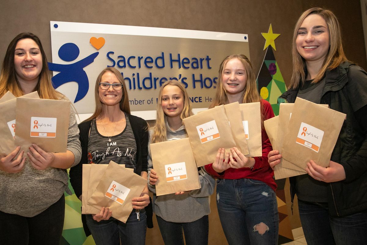 left: Chloe Place, Caryn Bothman, Maicy Bothman, Camie Bothman and Christina Ward of the Rosalia, Washington-based nonprofit Tough As Nails, are photographed with a portion of the 1,070 origami kits they delivered to Providence Sacred Heart Children’s Hospital on Dec. 18, 2019. Caryn Bothman began the nonprofit group with her high school-age daughters and their friends aimed at creating and donating craft kits to hospitalized children all in memory of her niece. (Libby Kamrowski / The Spokesman-Review)