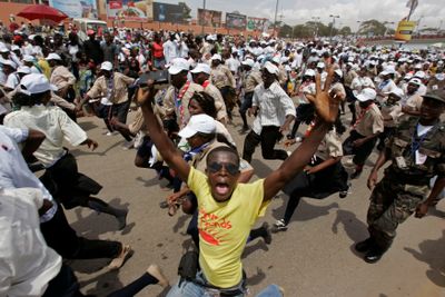 People run past as Pope Benedict XVI arrives at the airport in Luanda, Angola, on Friday.  (Associated Press / The Spokesman-Review)