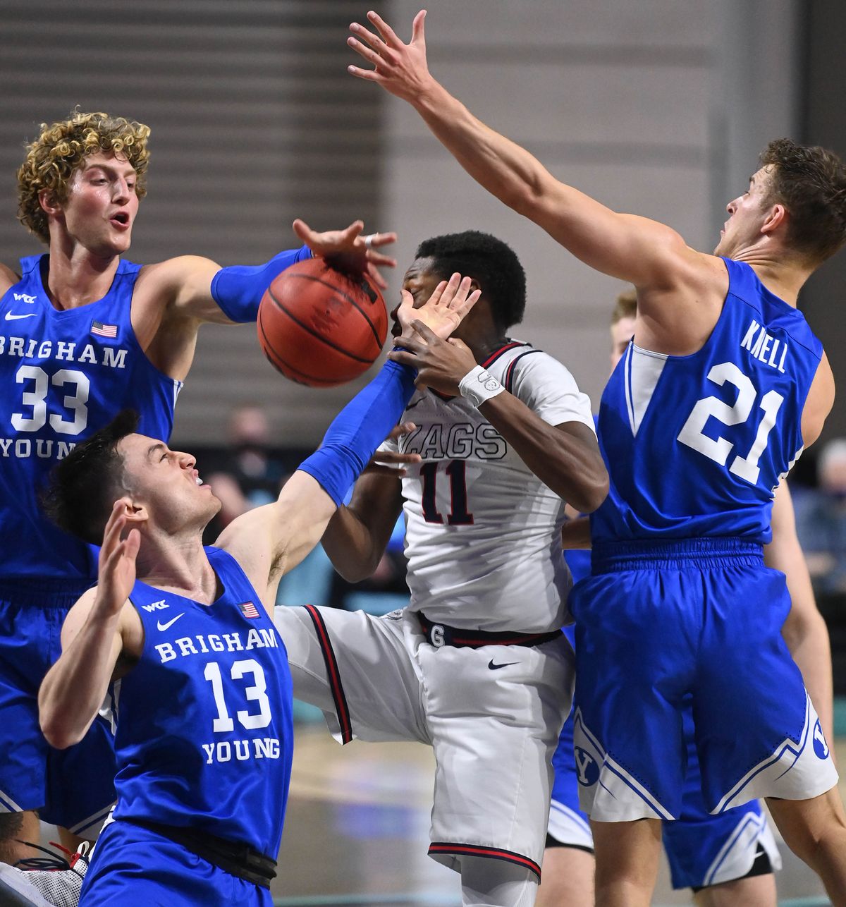 BYU forward Caleb Lohner (33), guard Alex Barcello (13) and guard Trevin Knell surround Gonzaga’s Joel Ayayi at the West Coast Conference Tournament final last March in Las Vegas.  (COLIN MULVANY/THE SPOKESMAN-REVIEW)