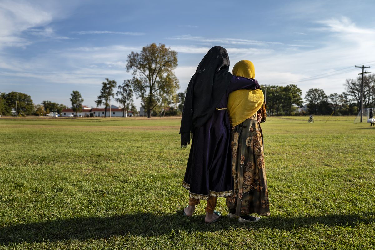 Afghan refugee girls watch a soccer game from a distance near the Village at the Ft. McCoy U.S. Army base on Thursday, Sept. 30, 2021 in Ft. McCoy, Wis. The fort is one of eight military installations across the country that are temporarily housing the tens of thousands of Afghans who were forced to flee their homeland in August after the U.S. withdrew its forces from Afghanistan and the Taliban took control.  (Barbara Davidson)