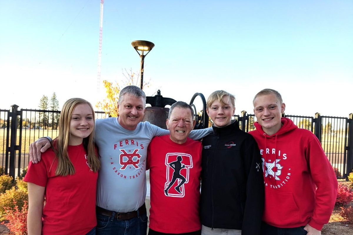 Chris Caviness (second from left), the boys cross country and girls track and field coach at Ferris, poses with his daughter Halle, father Herm, and sons Sean and Chad at the high school. Caviness died from cancer on Monday at 56. (Ferris athletics / Courtesy)