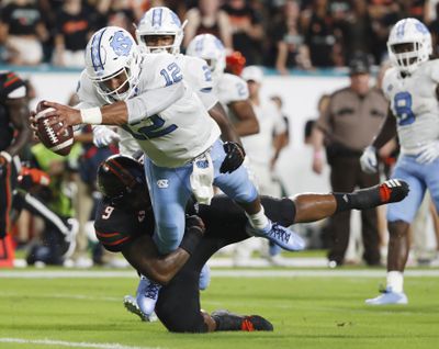 In this Sept. 27, 2018, file photo, North Carolina quarterback Chazz Surratt (12) dives in for a touchdown as he is tackled by Miami defensive lineman Gerald Willis III (9) during the first half of an NCAA college football game in Miami Gardens, Fla. Willis is second in the nation in tackles for loss with 12.5. (Wilfredo Lee / Associated Press)