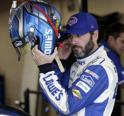 NASCAR Sprint Cup Series auto racing driver Jimmie Johnson prepares to don his helmet for a practice session at Kansas Speedway in Kansas City, Kan., Friday. (Colin E. Braley / Associated Press)