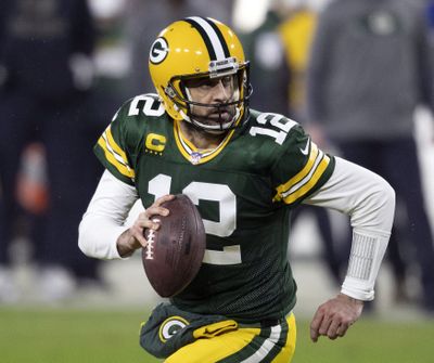 In this Jan. 16, 2021 photo, Green Bay Packers quarterback Aaron Rodgers runs during an NFL divisional playoff football game against the Los Angeles Rams in Green Bay, Wis. Packers general manager Brian Gutekunst says the team remains committed to Rodgers “for the foreseeable future” one year after trading up in the first round to draft the three-time MVP’s potential successor.  (Associated Press)