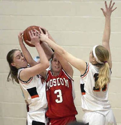 
Jenny McVeigh, left, and Kandice McArthur, right, of Post Falls tie up Moscow's Alisa Hart late in the game to force a turnover. 
 (Tom Davenport/ / The Spokesman-Review)