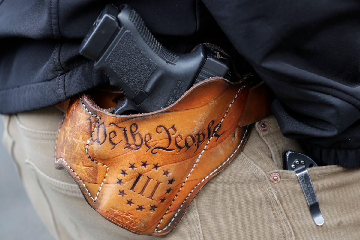 FILE – An attendee at a gun rights rally open carries his gun in a holster that reads “We the People” from the Preamble to the United States Constitution, Friday, Jan. 18, 2019, at the Capitol in Olympia, Wash. After a gunman killed 19 children and two teachers at an elementary school in Uvalde, Texas, on May 24, 2022, several pastors and rabbis around the country have challenged their conservative counterparts with this question: Are you pro-life if you are pro-guns?  (Ted S. Warren)