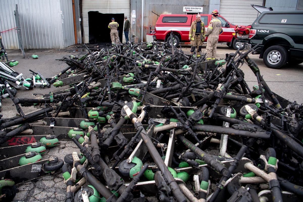 A pile of burned scooters are stacked outside an unmarked warehouse in East Spokane, Monday, Oct. 7, 2019, after firefighters put out a fire in the building overnight. The cause is under investigation. (Jesse Tinsley / The Spokesman-Review)