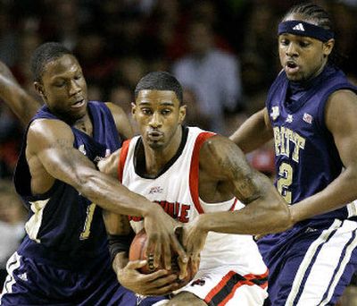 
Louisville's Taquan Dean, center, tries to keep control of the ball as Pittsburgh's Keith Benjamin reaches in to pull it away Sunday. 
 (Associated Press / The Spokesman-Review)