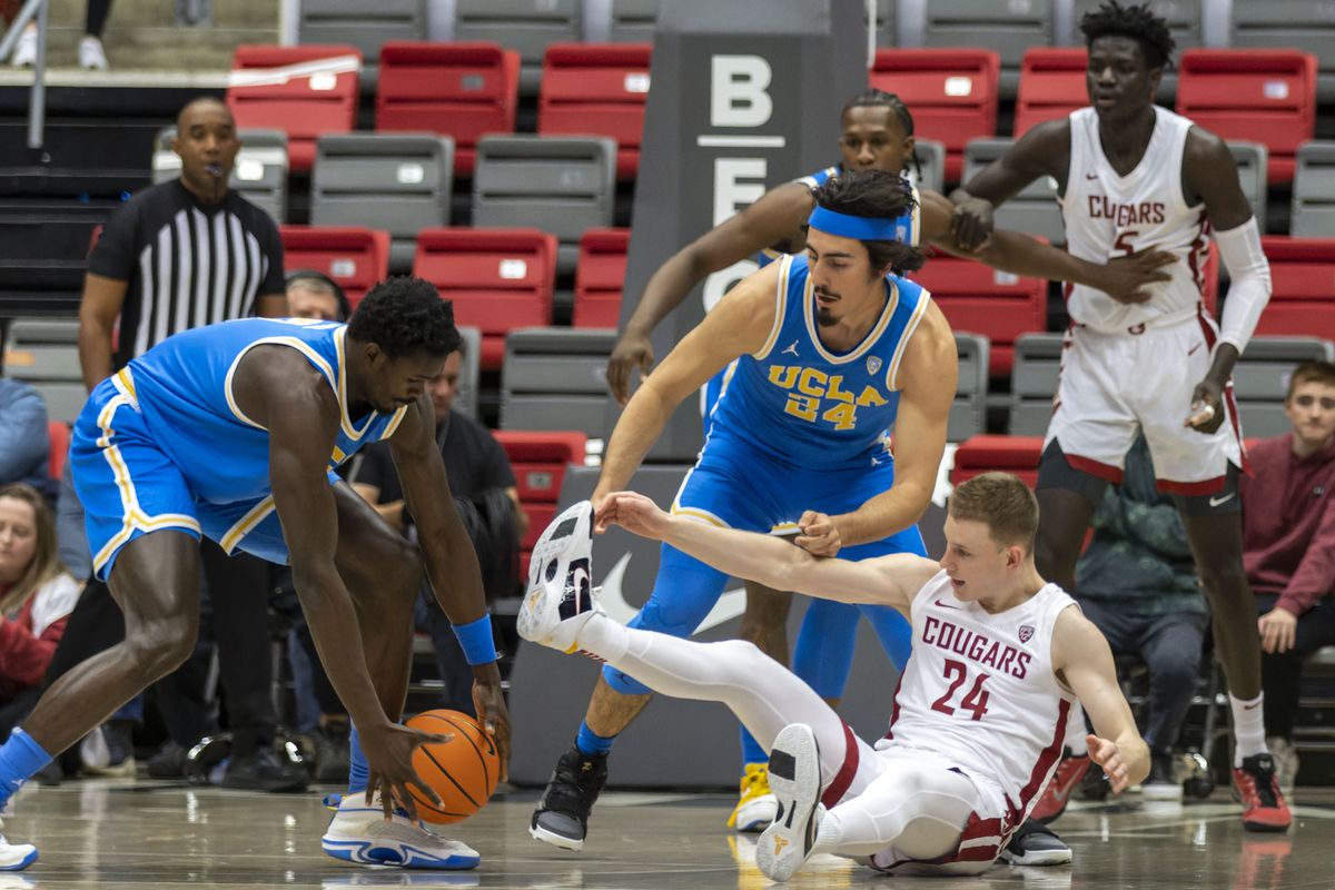 Washington State’s Justin Powell, right, and UCLA’s Jaime Jaquez Jr, center, and Adem Bona reach for a loose ball Friday at Beasley Coliseum in Pullman.  (Geoff Crimmins/For The Spokesman-Review)