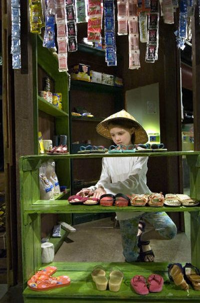 
Nine-year-old Alaina Bowers of Spokane Valley organizes shoes in the sari-sari store of Filipino village at Mobius Kids on Thursday afternoon. 
 (Holly Pickett / The Spokesman-Review)