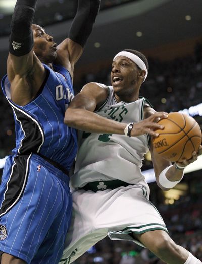 Celtics’ Paul Pierce, right, drives against Dwight Howard during the third quarter. Pierce scored 31  to lead Boston into the finals.  (Associated Press)