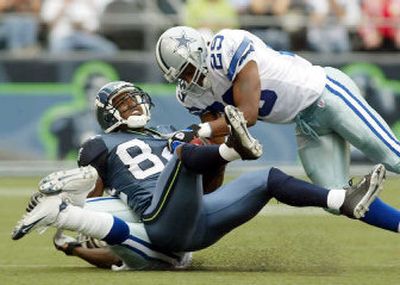 
Seattle's Bobby Engram is brought down by Dallas' Keith Davis, right, and Terence Newman, below, during the first half.
 (Associated Press / The Spokesman-Review)