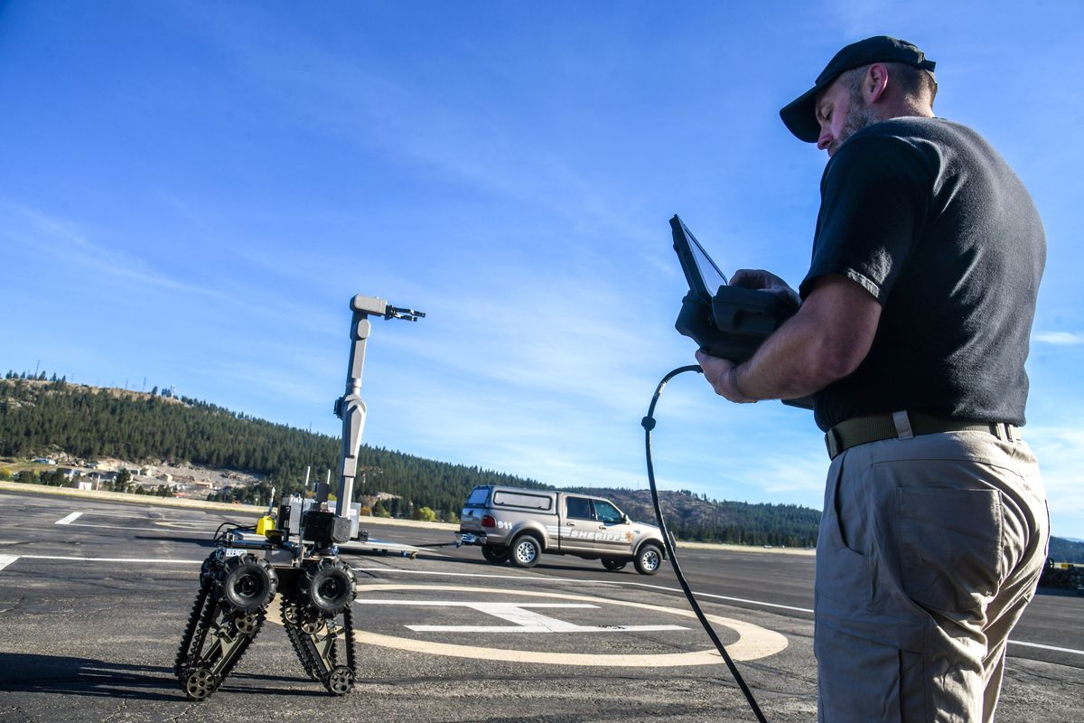 Spokane Police officer Toby Bryer, a member of the Spokane Regional Explosive Disposal Unit, controls the new bomb robot, the Telerob, into a giraffe position during a demonstration, Tuesday, April 27, 2021, at Felts Field. From this position, the robot can be used along an airplane aisle to search overhead bins.  (Dan Pelle/THE SPOKESMAN-REVIEW)