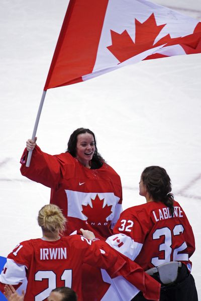 Goalkeeper Shannon Szabados of Canada (1) waves the Canadian flag after beating the USA 3-2 in overtime of the women's gold medal ice hockey game at the 2014 Winter Olympics on Thursday in  Sochi, Russia.  (Associated Press)