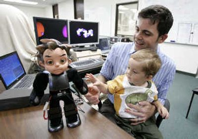 David Hanson holds his son, Zeno, on his lap as the two look at Hanson's robot creation, also named Zeno, at his office in Richardson, Texas. At 17 inches tall and weighing 6 pounds, the artificial Zeno is the culmination of five years of work by Hanson and a small group at Hanson Robotics. Associated Press
(Associated Press / The Spokesman-Review)