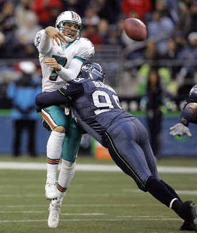 
Seattle's Rocky Bernard gets a grip on Miami quarterback A.J. Feeley.  
 (Associated Press / The Spokesman-Review)