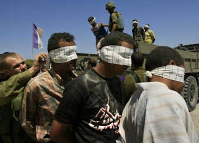 
An Israeli soldier  blindfolds  a Palestinian  lined up after his arrest during an army raid  Thursday. Associated Press
 (Associated Press / The Spokesman-Review)