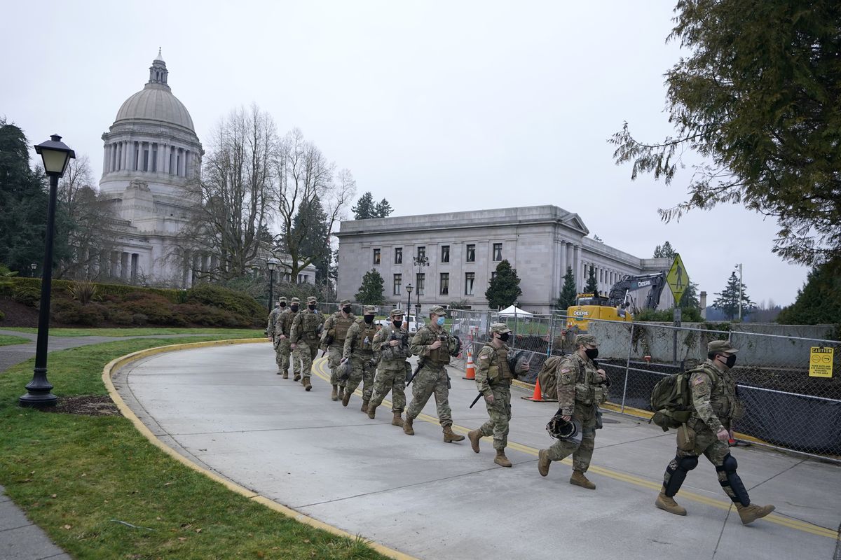 Washington National Guard members walk in formation away from the legislative building on Wednesday at the Capitol in Olympia.  (Ted S. Warren)