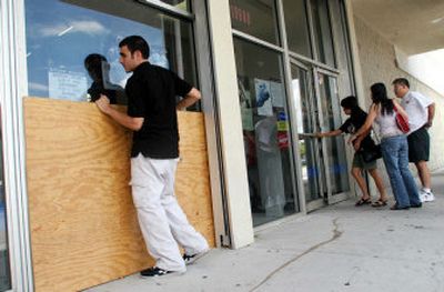 
Robert Chil, an employee at the Sports Authority in Miami, boards up the store's windows Monday in preparation for a strengthening Tropical Storm Rita. 
 (Associated Press / The Spokesman-Review)