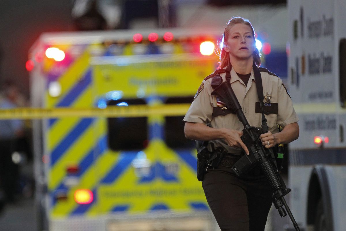An officer secures the area as police investigate a shooting that left at least two dead and four others wounded at Accent Signage Systems in Minneapolis, Thursday, Sept. 27, 2012. (Richard Tsong-taatarii / The Star Tribune)