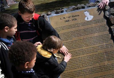 
Hutton Settlement children Ricky, from top, Ariez, Jacob and Mikey touch the memorial of Levi and May Hutton at the memorial's unveiling  April 3 at Fairmount Memorial Park in Spokane.
 (Rajah Bose / The Spokesman-Review)