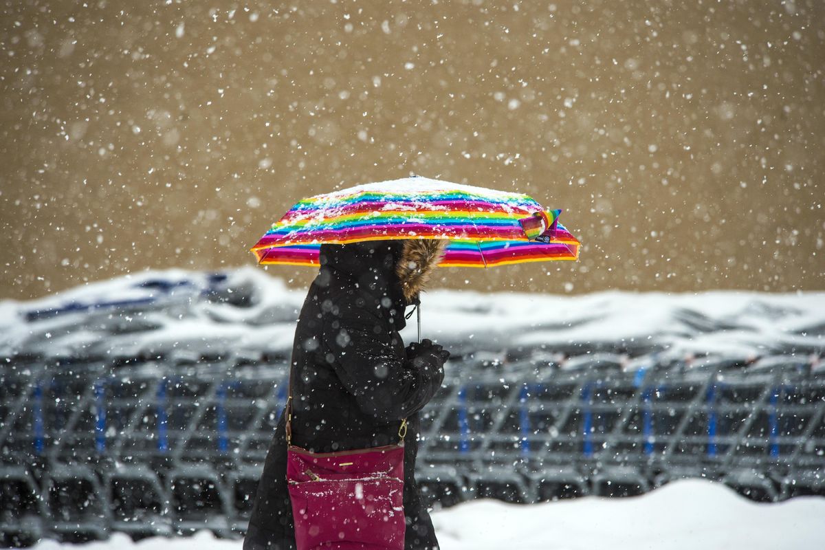 Giovanna Olguin, 29, makes her way to the Shadle Walmart through the snow storm that hit the area, Friday, Dec. 29, 2017, in Spokane, Wash. (Dan Pelle / The Spokesman-Review)