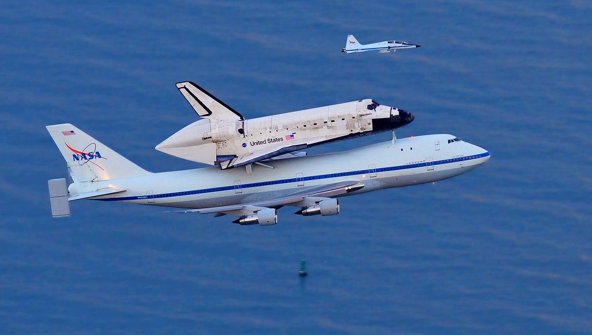 The space shuttle Discovery, mounted on top of a Boeing 747, flies over the Atlantic Ocean on Tuesday as it makes a pass over Cocoa Beach, Fla., heading to Washington, D.C. (Associated Press)