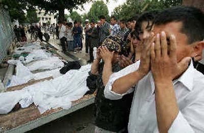 
People pray Saturday in front of the bodies of residents killed Friday in the eastern Uzbek town of Andijan. Government troops opened fire on civilians on Friday evening, and hundreds of people died. 
 (EPA / The Spokesman-Review)