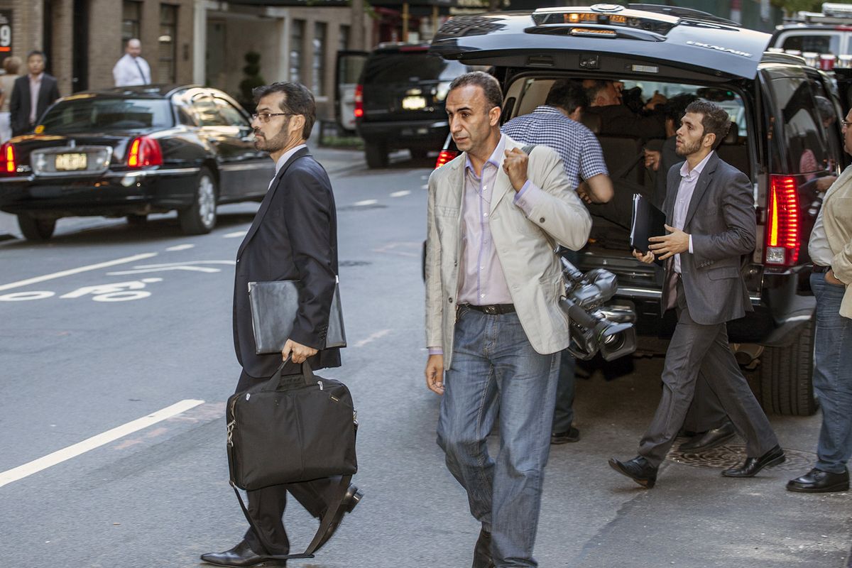 In this Sunday, Sept. 23, 2012 photo, Hassan Gol Khanban, cameraman and videographer with the Iranian News Agency assigned to the Iranian Presidential detail, center, arrives  at the Warwick Hotel in New York. Khanban, who was in New York covering the Iranian President