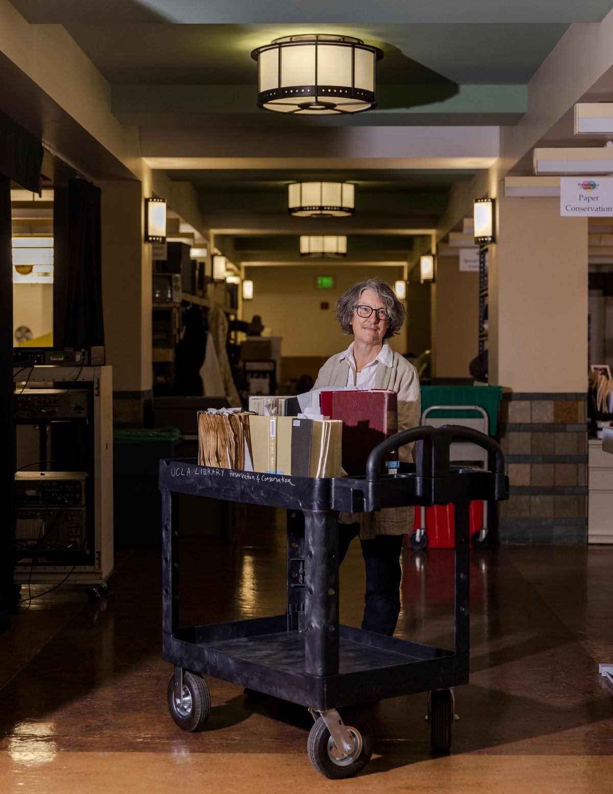 Chela Metzger, the head of preservation and conservation for the U.C.L.A. library, with a cart of books affected by a major equipment failure, that flooded many faculty offices including the library, in Los Angeles on Dec. 21, 2022. U.C.L.A and other institutions are developing new ways to combat humidity and other environmental factors. (Jessica Pons/The New York Times)  (JESSICA PONS)