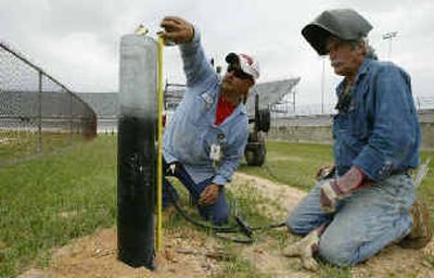 
Workers install and measure one of the 212 bases for the interior lights at Darlington Raceway back in November.
 (Associated Press / The Spokesman-Review)