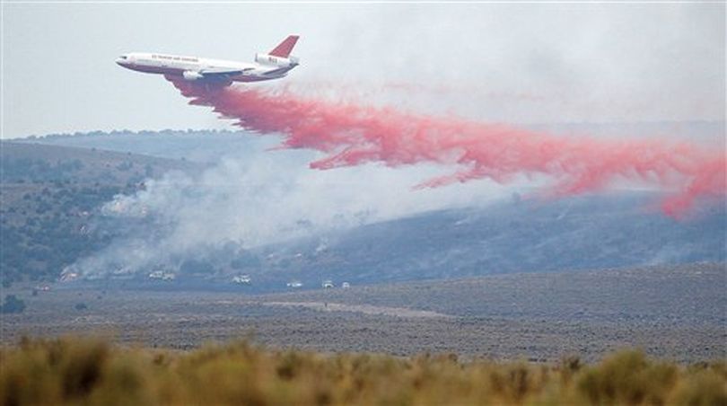 A VLAT, Very Large Aerial Tanker, that holds more than 10,000 gallons of fire retardant, makes a drop on Wednesday Aug. 8, 2012 on the Cave Canyon Fire a mile west of Oakley, Idaho. The fire is over 30,000 acres with fire fighters from the U.S. Bureau of Land Management, U.S. Forest Service and local fire departments. (AP/Times-News / Ashley Smith)