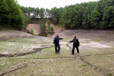 
Dmitry Zaytsev, left, and Vladimir Gryasnov, officials with the federal Emergency Situations Ministry, walk on the bottom of what was White Lake in Bolotnikovo, Russia. 
 (Los Angeles Times / The Spokesman-Review)