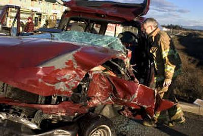 Spokane County District 10 Deputy Fire Chief Rod Heimbigner examines the remains of a Ford Pickup truck that was involved in a three vehicle injury accident at Hayford Road and 12th Avenue on Monday.
(Colin Mulvany / The Spokesman-Review)