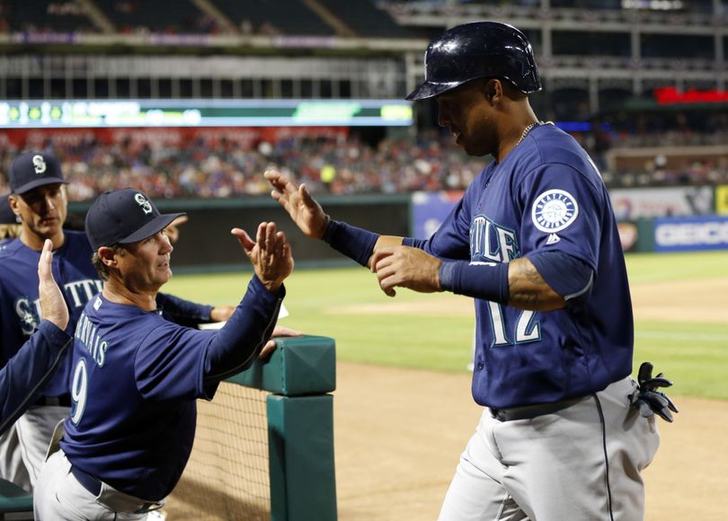 Seattle Mariners’ Leonys Martin is congratulated by manager Scott Servais (9) after Martin scored on a Nori Aoki single in the seventh inning of a baseball game against the Texas Rangers on Tuesday, April 5, 2016, in Arlington, Texas. (Jim Cowsert / Associated Press)