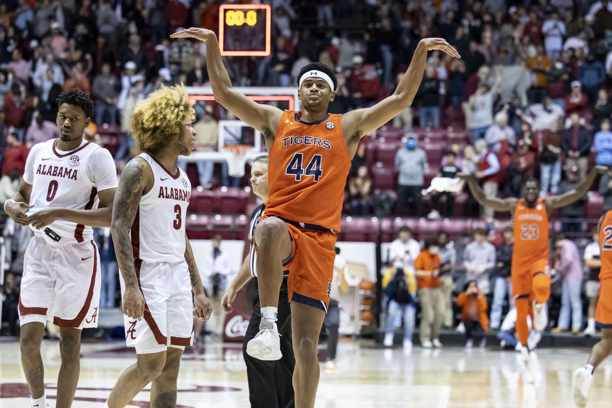 Auburn center Dylan Cardwell (44) celebrates with an Alabama signature 'Crimson Crane' (imitating a signature move from the movie the Karate Kid) in front of Alabama guard JD Davison (3) following a tight Auburn win, 81-77, in an NCAA college basketball game, Tuesday, Jan. 11, 2022, in Tuscaloosa, Ala.   (Associated Press)