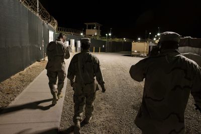 In this photo reviewed by the U.S. military, military personnel walk along the internal perimeter fences at  the Camp 4 detention facility  at Guantanamo Bay U.S. Naval Base.  (Associated Press / The Spokesman-Review)