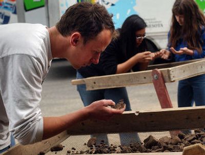 
Eastern Washington University anthropology major Alex Neumann sifts through dirt Sunday at the site where human bones and a wooden coffin have been found. 
 (Liz Kishimoto / The Spokesman-Review)