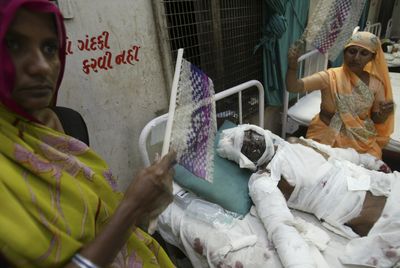 Hansa, right, with Usha, left, fans her husband Ishwar Bhai, 50, injured in Saturday’s blasts at a hospital in Ahmadabad, India.  (Associated Press / The Spokesman-Review)