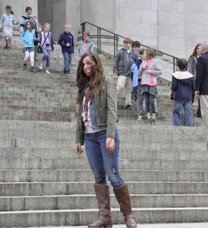 OLYMPIA -- Heather Hatton, an actress in a commercial supporting the state's tax incentive for films shot in Washington, prepares for a take on the Capitol steps as students on a tour stream past. (Jim Camden)