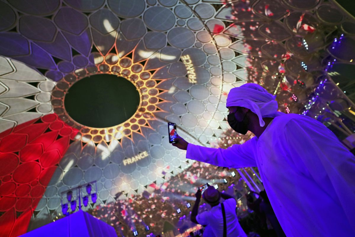 A man takes selfie under the dome of Al Wasl Plaza coloured in French national flag, during a French ceremonial day at the Dubai Expo 2020 in Dubai, United Arab Emirates, Saturday, Oct. 2, 2021.  (Kamran Jebreili)
