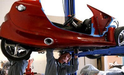 
Steve Hammack, right, and Travis Williams, left, work on the undercarriage of a motorcycle roadster in the Merlin Motors shop on Eden Road. Because of a high volume of orders, Merlin Motors will be moving to the Industrial Park. 
 (Liz-Anne Kishimoto / The Spokesman-Review)